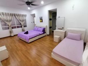 2 camas en una habitación blanca con sábanas moradas en Mysha KLIA F1 Homestay with pool,WiFi , Netflix en Kampong Chinchang