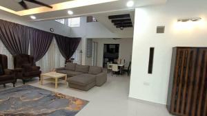 sala de estar con sofá y mesa en Mysha KLIA F1 Homestay with pool,WiFi , Netflix en Kampong Chinchang