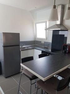 a kitchen with a refrigerator and a table and chairs at Coquet et confortable Appartement T2 in Rognac