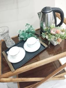 a table with plates and a tea kettle on it at Charming Home banglow in Karachi