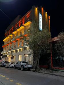 un edificio con coches estacionados frente a él en Hotel Viña de Italia en Córdoba