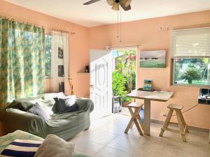 a living room with a green couch and a table at Cabarete Boutique Kite Hotel Garden Loft in Cabarete