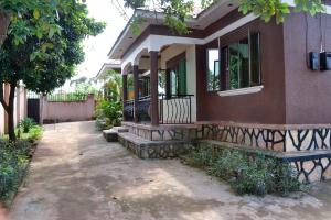 een huis met een veranda en een bank ervoor bij olive Palm Suites in Njeru