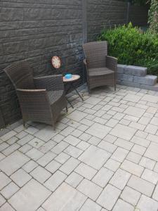 trzy krzesła i stół na patio w obiekcie Moderne Wohnung in ruhiger Lage w mieście Stolberg