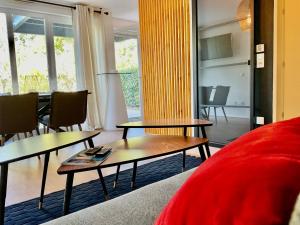 奧貝奈的住宿－Le Safran，客厅配有两张桌子和一张红色沙发