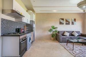 a kitchen and a living room with a couch at Perle Rare a Prestigia - Vue Sur Golf in Marrakech