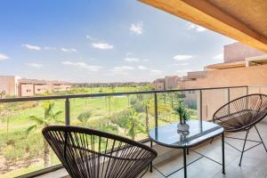 uma varanda com uma mesa e cadeiras e uma vista em Perle Rare a Prestigia - Vue Sur Golf em Marrakech
