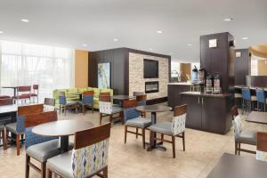 un restaurante con mesas y sillas y una cocina en Comfort Suites Lake City en Lake City