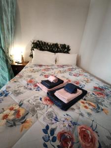 uma cama com uma colcha floral e toalhas em House Village ** em São Bartolomeu de Messines