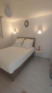 a bedroom with a bed with a clock on the wall at T2 Vue sur la Basilique de Notre Dame de la Garde in Marseille