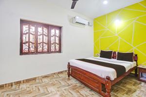 een slaapkamer met een bed en een raam bij Ferns Guest House in Calangute