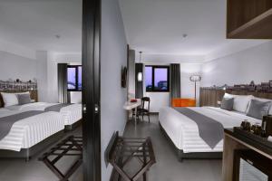 Un pat sau paturi într-o cameră la Hotel Neo Malioboro by ASTON