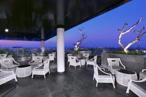 a restaurant with white chairs and a view of the city at Hotel Neo Malioboro by ASTON in Yogyakarta