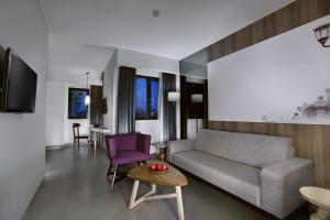 a living room with a couch and a table at Hotel Neo Malioboro by ASTON in Yogyakarta