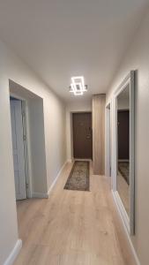 an empty room with a hallway with wood floors at Greimo apartamentai in Šiauliai