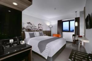 Un pat sau paturi într-o cameră la Hotel Neo Malioboro by ASTON