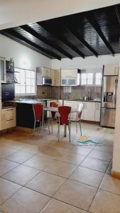 una cocina con sillas rojas y una mesa. en Casa Vacacional Lomas de Guayamury, en Paraguchi