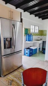 uma cozinha com um frigorífico de aço inoxidável e uma cadeira vermelha em Casa Vacacional Lomas de Guayamury em Paraguchi