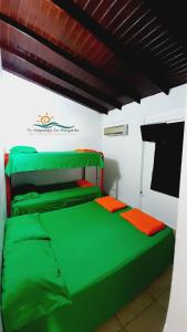 Paraguachi的住宿－Casa Vacacional Lomas de Guayamury，一间位于客房内的带绿床的卧室