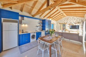 a kitchen with blue cabinets and a table and chairs at Villa Flower Blue Patara in Gelemiş