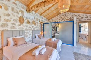 a bedroom with two beds and a stone wall at Villa Flower Blue Patara in Gelemiş +32 photos