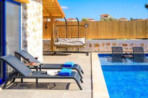 a patio with two chairs and a swimming pool at Villa Flower Blue Patara in Gelemiş