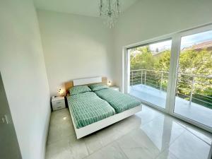 a bedroom with a bed and a large window at 4 Bedroom House On The Hill in Ljubljana