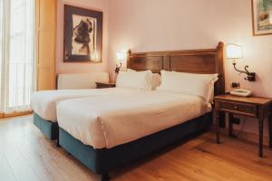 ein Hotelzimmer mit einem großen Bett und einem Telefon in der Unterkunft II Guelfo Bianco in Florenz