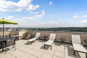 a patio with tables and chairs and an umbrella at Modern Apartment in the Center at Pentagon City in Arlington