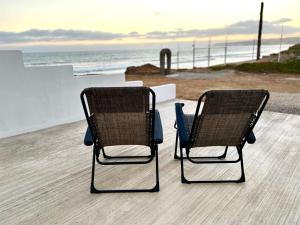 dos sillas sentadas en una terraza con vistas al océano en Mar de Crystal, en Puerto Nuevo
