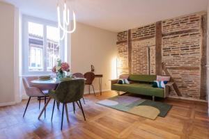 - un salon avec une table et un canapé vert dans l'établissement Le VB du 21, à Bourg-en-Bresse