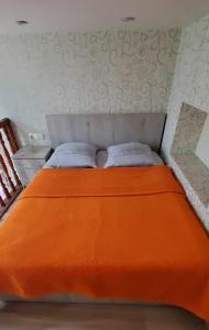 1 cama con edredón de naranja en un dormitorio en Sololaki Hill en Tiflis