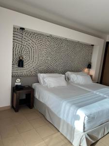 a bedroom with a large white bed and a side table at Hotel Barbato in Naples