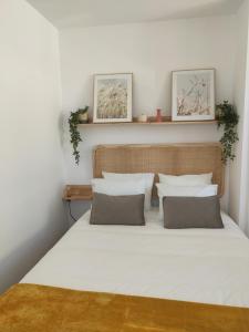 um quarto com uma cama com lençóis brancos e almofadas em Aveiro Ria House em Aveiro