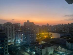 a city skyline at sunset with buildings and lights at Studio JP Redenção in Porto Alegre