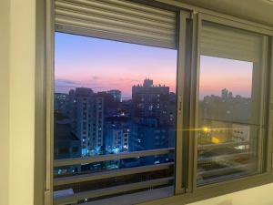 a window with a view of a city skyline at Studio JP Redenção in Porto Alegre