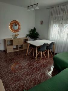 ein Wohnzimmer mit einem Tisch, Stühlen und einem Spiegel in der Unterkunft La Casa de Vicente y Soledad in Ruidera