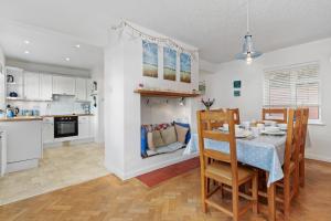 una cucina e una sala da pranzo con tavolo e sedie di Ruby Cottage - Beachside Cottage with Views a Saundersfoot