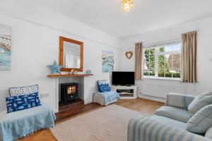 un soggiorno con divano e camino di Ruby Cottage - Beachside Cottage with Views a Saundersfoot Altre 27 foto