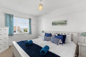 una camera da letto con un letto grande con cuscini blu di Ruby Cottage - Beachside Cottage with Views a Saundersfoot