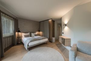 1 dormitorio con 1 cama y 1 sofá en Hotel Das Dorner, en Lagundo