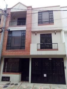 - un grand bâtiment en briques avec des portes et des fenêtres noires dans l'établissement Apartamento El Rosal Cundinamarca, à El Rosal