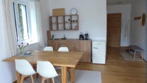 eine Küche mit einem Holztisch und weißen Stühlen in der Unterkunft Wohnen im schönsten Viertel Wiens in Wien