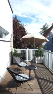 eine Terrasse mit einem Tisch, einem Sonnenschirm und Stühlen in der Unterkunft Wohnen im schönsten Viertel Wiens in Wien