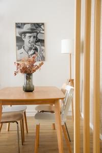 a dining room table with a picture of a man at La Belle Epoque - Proche Gare - Parking Gratuit in Angoulême