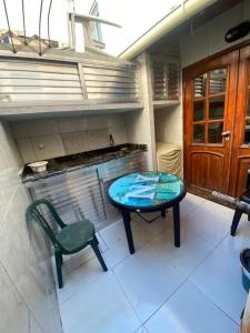 una mesa y una silla verde en la cocina en Portal dos Anjos 03, en Arraial do Cabo