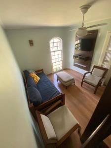 a living room with a bed and a chair at Portal dos Anjos 03 in Arraial do Cabo