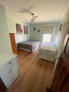 a bedroom with two beds and a ceiling fan at Portal dos Anjos 03 in Arraial do Cabo