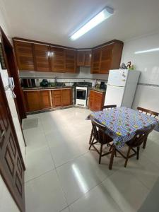 cocina con mesa y nevera en Portal dos Anjos 03, en Arraial do Cabo