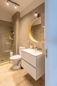 uma casa de banho com um lavatório, um WC e um espelho. em Aqua Vista Infinity Apartament Lux Vedere La Mare - Resort & Spa em Mamaia Nord – Năvodari